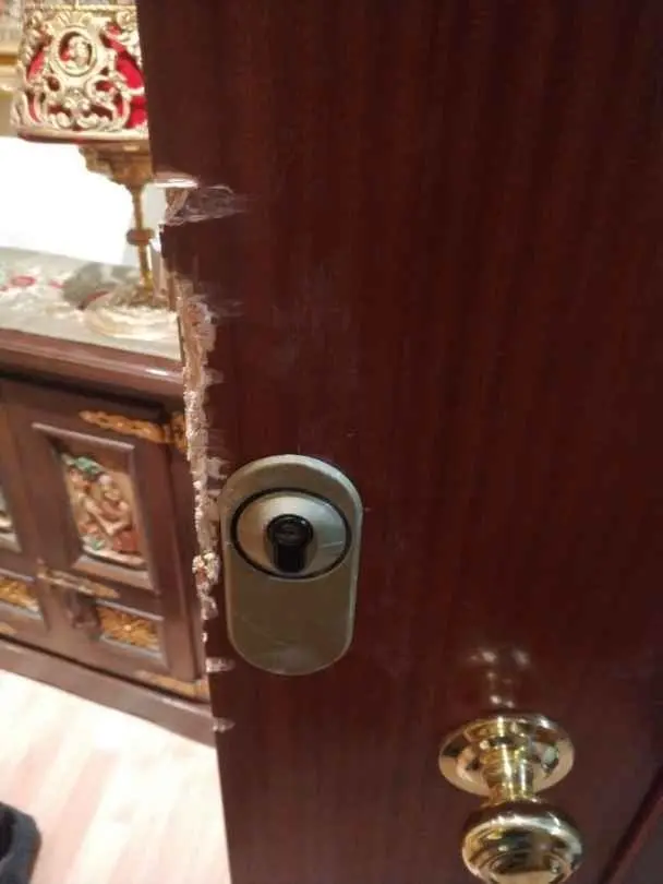 Bombín nuevo con escudo protector dorado en una puerta de madera